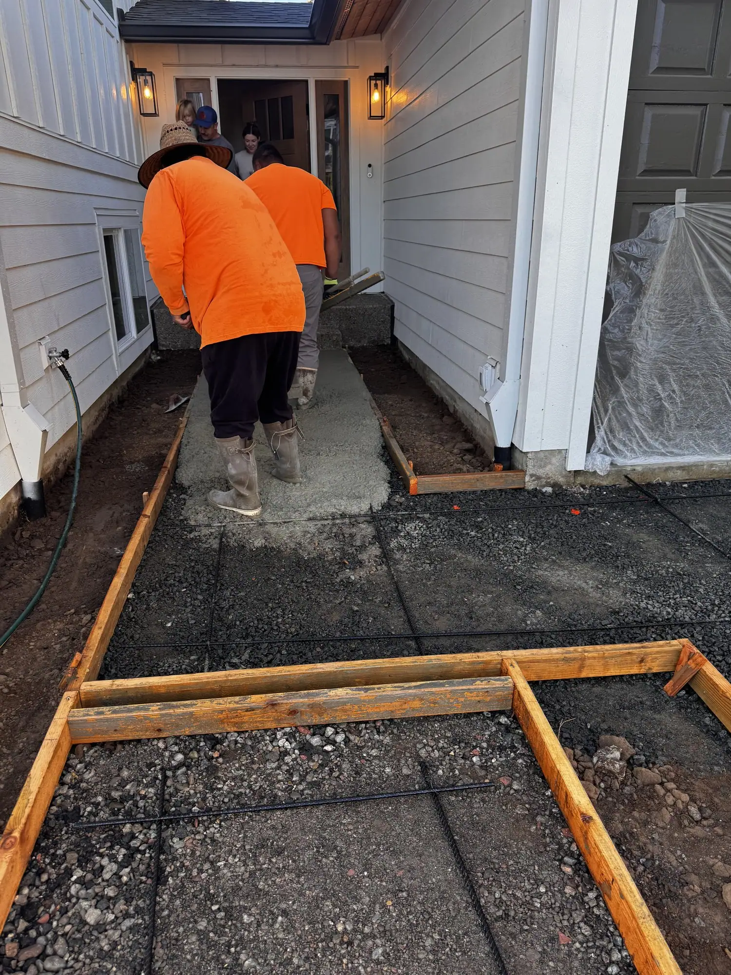 MJ Concrete crew setting forms for a walkway at a front entry